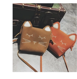 Detail of two mini cat-shaped bags in brown and orange faux suede with embroidery