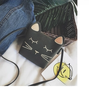 Detailed embroidery of cat whiskers and ears on a black felt mini crossbody shoulder bag