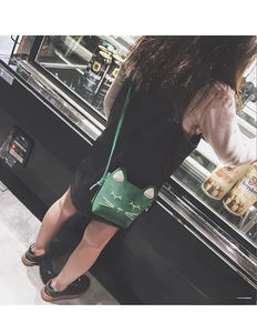 Green cat-shaped crossbody bag for girls showing embroidered details and strap