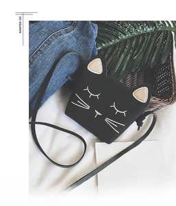 Detail of cute black cat crossbody bag for girls with embroidery and pink ears accent