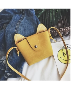 Close-up of yellow cat ear crossbody bag featuring matte texture and metal snap closure