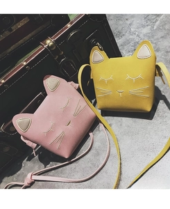 Detail of pink and yellow cat crossbody bags with 3D ears and embroidered feline expressions