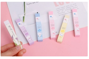 Detail shot of pastel long erasers in floral and cartoon designs held for size reference