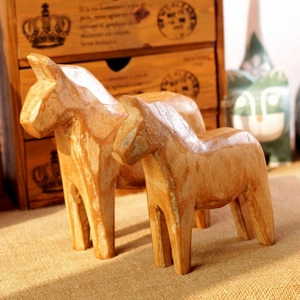 Detail of two Nordic hand-carved wooden horse figurines showing natural grain and texture