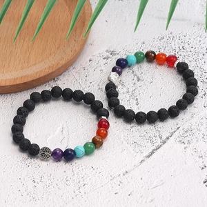 Macro shot of chakra lava stone bracelets featuring tree of life and buddha head charms
