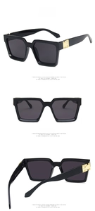 Vue détaillée des lunettes de soleil carrées noires avec charnières en métal coeur doré