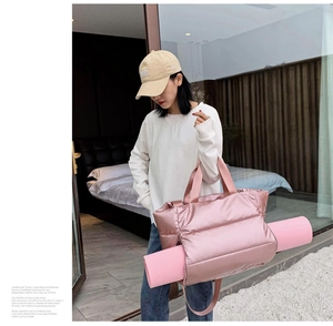 Pink quilted fitness travel bag featuring an integrated holder for a pink yoga mat