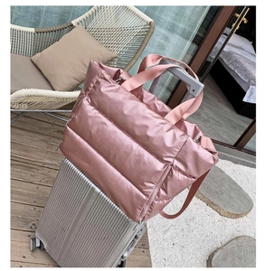 Pink quilted waterproof fitness bag with a back strap sleeve for suitcase handles