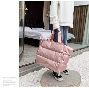 Close-up of pink quilted nylon tote bag with glossy finish and silver zipper detail