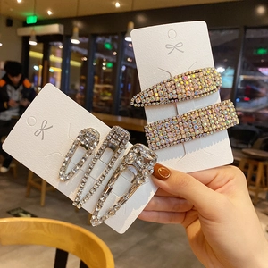 Detailed view of heavy metal gold chain hair clips set with glittering rhinestones