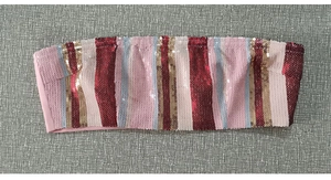 Dettaglio del top a fascia con paillettes a righe rosa e oro dalla trama luccicante