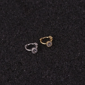 Close-up of gold and silver mini cartilage ear hoops with sparkling zircon inlays