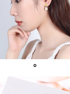 Close-up of a model wearing creative fried egg studs and yellow bead earrings