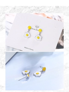 Detail view of cute poached egg stud earrings with enamel dripping oil craft and silver base
