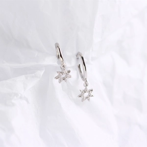 Macro shot of silver S925 star hoop earrings with sparkling crystal pavé on white paper