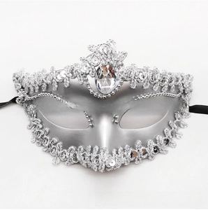 Close-up of silver masquerade mask with glittering sequins, lace edges and teardrop gem