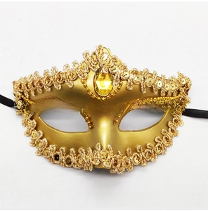 Detailed view of luxury gold masquerade mask with lace trims and teardrop gemstone