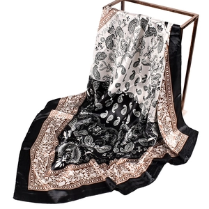 Elegant 90x90 black and white paisley print square silk scarf hanging on metal stand