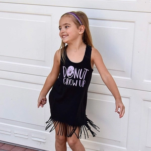Close-up of black sleeveless dress for girls with Donut Grow Up print and tassel hem
