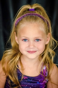 Detail of sequin glitter headband in purple worn with a matching gymnastics leotard