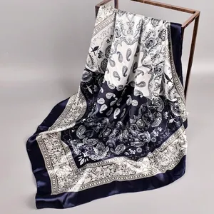 Detailed view of navy blue and white paisley pattern satin silk square scarf texture