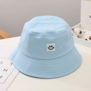 Close-up of light blue cotton canvas sun hat featuring a cute smiling face patch