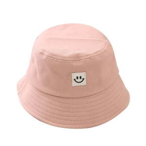 Pink canvas kids sun hat with a cute smiley face patch shown on a white background
