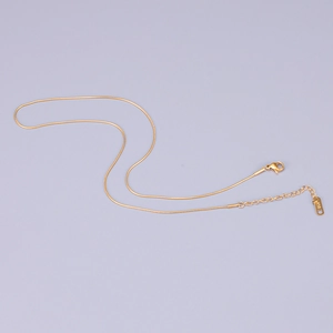 Detail of 18K gold-plated snake chain showing lobster clasp and K18 hallmark tag