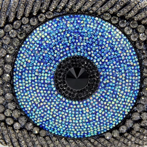 Macro detail of blue and silver evil eye crystal rhinestones on luxury clutch bag