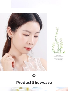 Close-up of rose gold curved earrings with paved white zircons on a model
