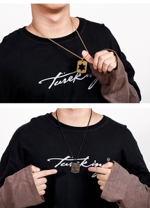 Detail view of hexagram shield pendants in gold and black finishes on models