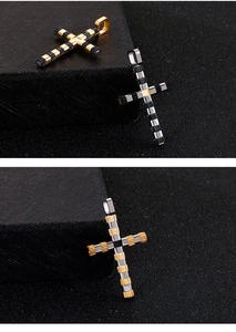 Macro shot of two-tone stainless steel cross pendants on a textured black surface