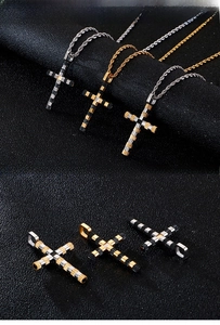 Detail view of industrial gear texture cross pendants in silver, gold, and black steel