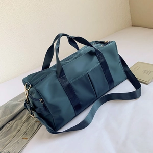 Detail of teal waterproof sports bag with separate shoe compartment and shoulder strap