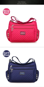 Detail view of quilted nylon crossbody bag with multi-zipper pockets in rose and navy