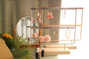 Detail of iron earring stand with pine wood base displaying silver and rose gold jewelry