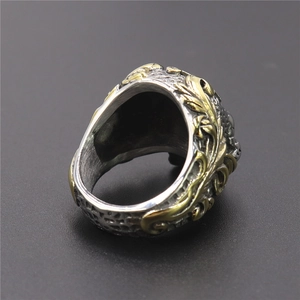 Detail of vintage silver and gold skull ring with intricate embossed texture on the band