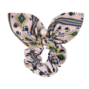 Detail of pink satin bow scrunchie with ethnic print and white imitation pearl pendant