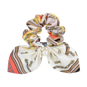 Detail of silk hair scrunchie with vintage belt pattern and elegant pearl charm