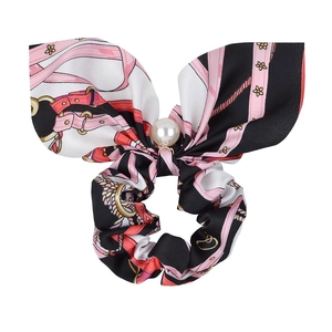 Detailed view of silk-like bow scrunchie featuring vintage patterns and a pearl pendant