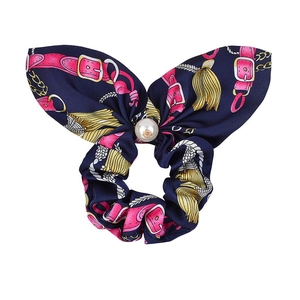 Detail of navy blue satin bow scrunchie with pink strap pattern and pearl pendant center