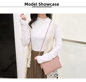 Detail shot of a pink leather envelope crossbody bag with a gold metal magnetic flap