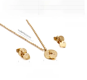Detail of gold stainless steel necklace and earrings with Roman numerals and heart pendant