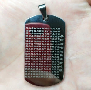 Macro detail of silver rectangle keychain with Heart Sutra Chinese text engraving
