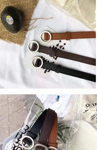 Detailed view of narrow PU leather belts in black and brown with silver round buckles