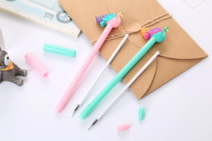 Close-up of pink and mint green peacock-shaped pens with refills on a desk setup