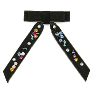 Detail of dark green velvet bow hair clip with embedded pearls and colorful crystals