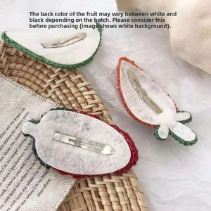 Detailed view of hand-knitted fruit hair clips with strawberry and carrot crochet designs