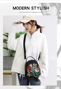 Detail of waterproof nylon crossbody bag with colorful leaf patterns and multi-zipper layers