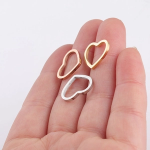Three hollow heart-shaped stainless steel charms in gold, rose gold and silver colors